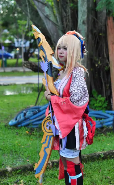 Banjarmasin, Endonezya - 25 Haziran 2023: Kostümlü güzel bir kadın oyununun portresi (Cosplayer as Character Yoimiya) Genshin Impact filminde oynanabilir bir karakterdir. 