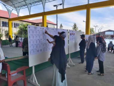 Banjarmasin, Endonezya - 14 Şubat 2024: Banjarmasin 'de geçerli bir sandık merkezinde cumhurbaşkanı ve konsey üyelerinin seçilmesinde bir gözlemci seçim sürecini ve güvenliğini izliyor.