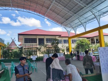 Banjarmasin, Endonezya - 14 Şubat 2024: Banjarmasin 'de geçerli bir sandık merkezinde cumhurbaşkanı ve konsey üyelerinin seçilmesinde bir gözlemci seçim sürecini ve güvenliğini izliyor.