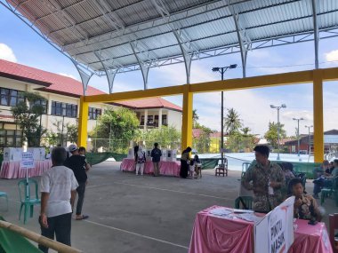 Banjarmasin, Endonezya - 14 Şubat 2024: Banjarmasin 'de geçerli bir sandık merkezinde cumhurbaşkanı ve konsey üyelerinin seçilmesinde bir gözlemci seçim sürecini ve güvenliğini izliyor.