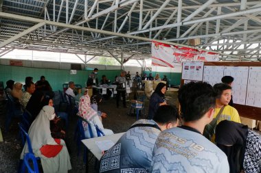 Banjarmasin, Endonezya - 14 Şubat 2024: Banjarmasin 'de geçerli bir sandık merkezinde cumhurbaşkanı ve konsey üyelerinin seçilmesinde bir gözlemci seçim sürecini ve güvenliğini izliyor.