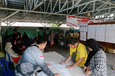 Banjarmasin, Endonezya - 14 Şubat 2024: Banjarmasin 'de geçerli bir sandık merkezinde cumhurbaşkanı ve konsey üyelerinin seçilmesinde bir gözlemci seçim sürecini ve güvenliğini izliyor.