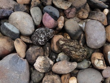 Yuvarlak çakıl taşlarıyla soyut desenli arka plan. Plaj konseptinde tatil tatili. Yüksek kalite fotoğraf. Kaya dokusu olan bir parça..