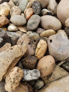 Yuvarlak çakıl taşlarıyla soyut desenli arka plan. Plaj konseptinde tatil tatili. Yüksek kalite fotoğraf. Kaya dokusu olan bir parça..