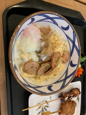 Japon yemeği. Lezzetli aromalı et ya da tempura ile servis edilen, taze soğan ve yumurta sunan Carbonara Curry Udon Marugame Kalın udon eriştesi..