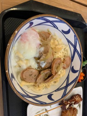 Japon yemeği. Lezzetli aromalı et ya da tempura ile servis edilen, taze soğan ve yumurta sunan Carbonara Curry Udon Marugame Kalın udon eriştesi..