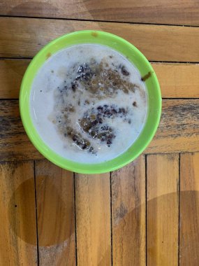 Yeşil fasulye lapası ve hindistan cevizi sütlü siyah pirinç ve yeşil kase ile yapılan geleneksel Endonezya tatlısı.