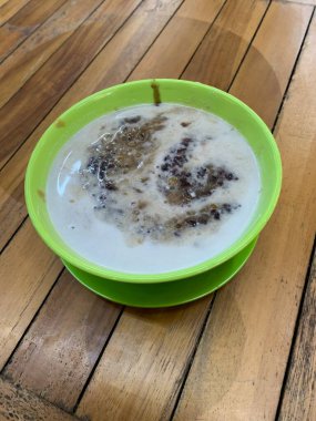 Yeşil fasulye lapası ve hindistan cevizi sütlü siyah pirinç ve yeşil kase ile yapılan geleneksel Endonezya tatlısı.