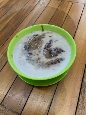 Yeşil fasulye lapası ve hindistan cevizi sütlü siyah pirinç ve yeşil kase ile yapılan geleneksel Endonezya tatlısı.