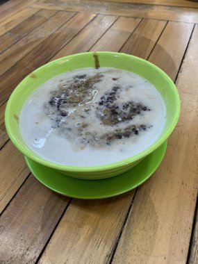 Yeşil fasulye lapası ve hindistan cevizi sütlü siyah pirinç ve yeşil kase ile yapılan geleneksel Endonezya tatlısı.