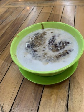 Yeşil fasulye lapası ve hindistan cevizi sütlü siyah pirinç ve yeşil kase ile yapılan geleneksel Endonezya tatlısı.