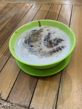 Yeşil fasulye lapası ve hindistan cevizi sütlü siyah pirinç ve yeşil kase ile yapılan geleneksel Endonezya tatlısı.