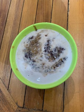 Yeşil fasulye lapası ve hindistan cevizi sütlü siyah pirinç ve yeşil kase ile yapılan geleneksel Endonezya tatlısı.