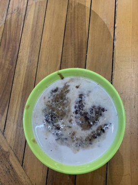 Yeşil fasulye lapası ve hindistan cevizi sütlü siyah pirinç ve yeşil kase ile yapılan geleneksel Endonezya tatlısı.