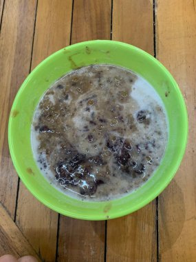 Yeşil fasulye lapası ve hindistan cevizi sütlü siyah pirinç ve yeşil kase ile yapılan geleneksel Endonezya tatlısı.