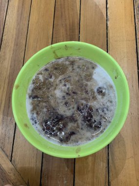 Yeşil fasulye lapası ve hindistan cevizi sütlü siyah pirinç ve yeşil kase ile yapılan geleneksel Endonezya tatlısı.