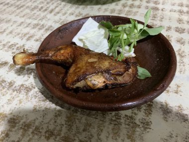 Ayam bakar Penyet, taze sebze, salatalık ve fesleğen yapraklı sıcak biberli kızarmış tavuktur.