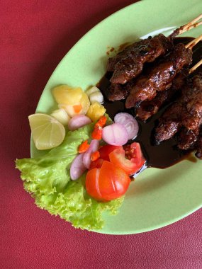 Keçi ve geyik eti satay baharatlı, sonra ızgarada mükemmelce pişirildi ve dilimlenmiş lahana, domates, arpacık soğanı, arnavut biberi ve limonla servis edildi..