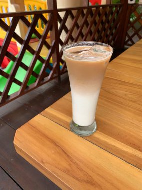 Bir bardak buzlu İspanyol latte cortado ve minimal stil kafede soğuk bir kahve, soğuk yaz içeceği..