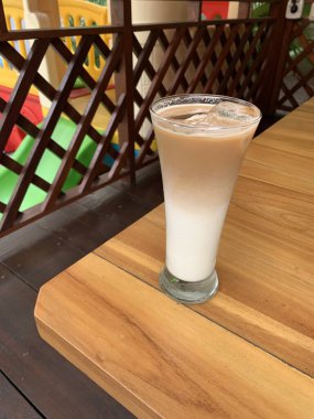 Bir bardak buzlu İspanyol latte cortado ve minimal stil kafede soğuk bir kahve, soğuk yaz içeceği..