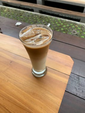 Bir bardak buzlu İspanyol latte cortado ve minimal stil kafede soğuk bir kahve, soğuk yaz içeceği..