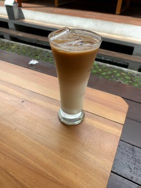 Bir bardak buzlu İspanyol latte cortado ve minimal stil kafede soğuk bir kahve, soğuk yaz içeceği..