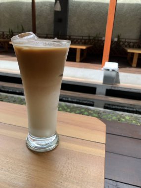Bir bardak buzlu İspanyol latte cortado ve minimal stil kafede soğuk bir kahve, soğuk yaz içeceği..
