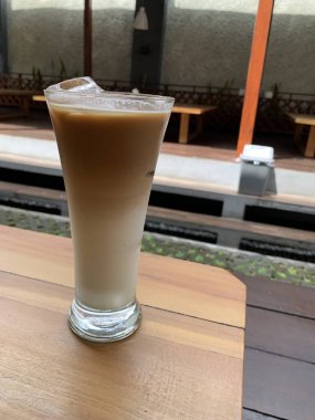 Bir bardak buzlu İspanyol latte cortado ve minimal stil kafede soğuk bir kahve, soğuk yaz içeceği..