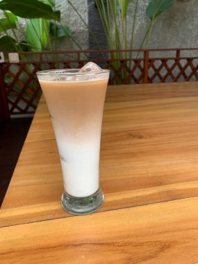 Bir bardak buzlu İspanyol latte cortado ve minimal stil kafede soğuk bir kahve, soğuk yaz içeceği..