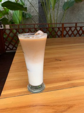 Bir bardak buzlu İspanyol latte cortado ve minimal stil kafede soğuk bir kahve, soğuk yaz içeceği..