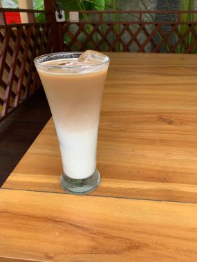 Bir bardak buzlu İspanyol latte cortado ve minimal stil kafede soğuk bir kahve, soğuk yaz içeceği..