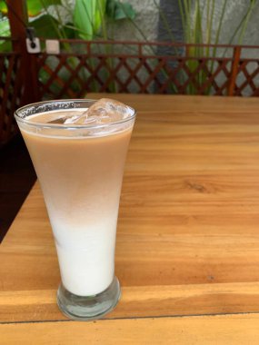 Bir bardak buzlu İspanyol latte cortado ve minimal stil kafede soğuk bir kahve, soğuk yaz içeceği..