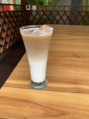 Bir bardak buzlu İspanyol latte cortado ve minimal stil kafede soğuk bir kahve, soğuk yaz içeceği..