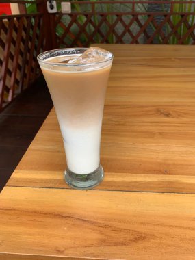 Bir bardak buzlu İspanyol latte cortado ve minimal stil kafede soğuk bir kahve, soğuk yaz içeceği..