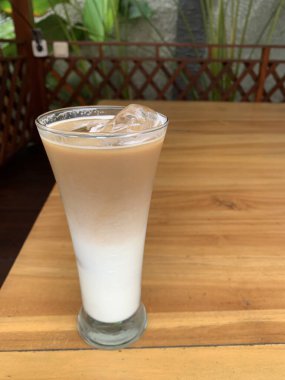 Bir bardak buzlu İspanyol latte cortado ve minimal stil kafede soğuk bir kahve, soğuk yaz içeceği..
