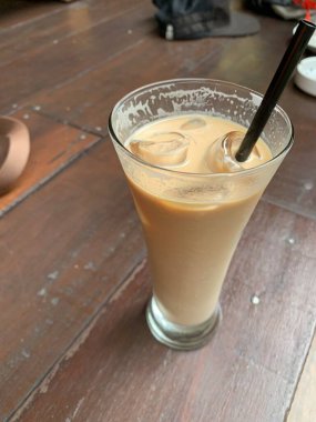 Bir bardak buzlu İspanyol latte cortado ve minimal stil kafede soğuk bir kahve, soğuk yaz içeceği..