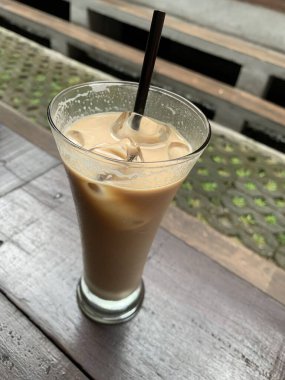 Bir bardak buzlu İspanyol latte cortado ve minimal stil kafede soğuk bir kahve, soğuk yaz içeceği..