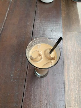 Bir bardak buzlu İspanyol latte cortado ve minimal stil kafede soğuk bir kahve, soğuk yaz içeceği..