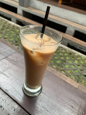 Bir bardak buzlu İspanyol latte cortado ve minimal stil kafede soğuk bir kahve, soğuk yaz içeceği..