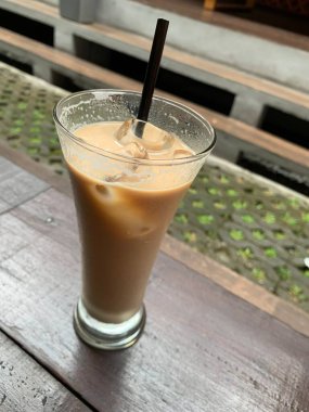 Bir bardak buzlu İspanyol latte cortado ve minimal stil kafede soğuk bir kahve, soğuk yaz içeceği..