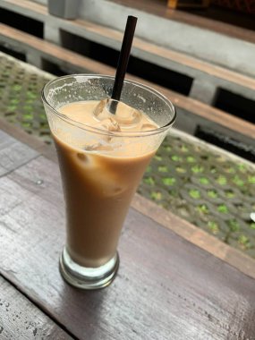 Bir bardak buzlu İspanyol latte cortado ve minimal stil kafede soğuk bir kahve, soğuk yaz içeceği..