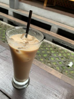 Bir bardak buzlu İspanyol latte cortado ve minimal stil kafede soğuk bir kahve, soğuk yaz içeceği..