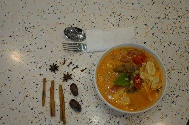 Tayland usulü sıcak ve baharatlı kırmızı tavuk ve bambu filizli köri. Hint arpacık soğanı, sarımsak, kırmızı kuru biber ve çerçevede fesleğen dalı gibi köri ezmesi için malzemeler. Japon körili ramen..