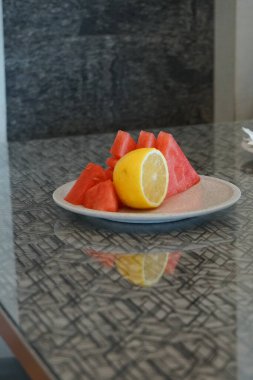 Kahvaltıda beyaz tabakta tropikal konseptle karışık taze meyve yakın çekim. Bir sürü karpuz, kavun, üzüm, ananas. ve papaya. seçici odak.