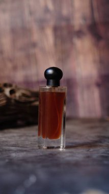 Yan yana dizilmiş ahşap kapaklı lüks cam parfüm şişesi kompozisyona dengeli bir estetik yaratıyor.. 