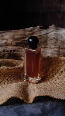 Yan yana dizilmiş ahşap kapaklı lüks cam parfüm şişesi kompozisyona dengeli bir estetik yaratıyor.. 