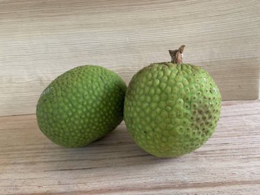 Moraceae ailesinin tüm ekmek meyvesi üyeleri Artocarpus altilis ve dilimler ahşap yüzeyde sergilenir. Nişastalı, patates gibi kızarmasıyla tanınır. yiyecek fotoğrafçılığı, meyve fotoğrafçılığı yiyecek ve içecek.