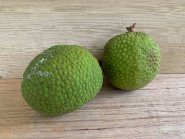 Moraceae ailesinin tüm ekmek meyvesi üyeleri Artocarpus altilis ve dilimler ahşap yüzeyde sergilenir. Nişastalı, patates gibi kızarmasıyla tanınır. yiyecek fotoğrafçılığı, meyve fotoğrafçılığı yiyecek ve içecek.