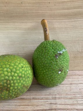 Moraceae ailesinin tüm ekmek meyvesi üyeleri Artocarpus altilis ve dilimler ahşap yüzeyde sergilenir. Nişastalı, patates gibi kızarmasıyla tanınır. yiyecek fotoğrafçılığı, meyve fotoğrafçılığı yiyecek ve içecek.