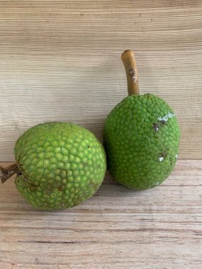 Moraceae ailesinin tüm ekmek meyvesi üyeleri Artocarpus altilis ve dilimler ahşap yüzeyde sergilenir. Nişastalı, patates gibi kızarmasıyla tanınır. yiyecek fotoğrafçılığı, meyve fotoğrafçılığı yiyecek ve içecek.